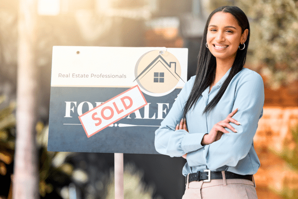 real estate agent standing next to a signage